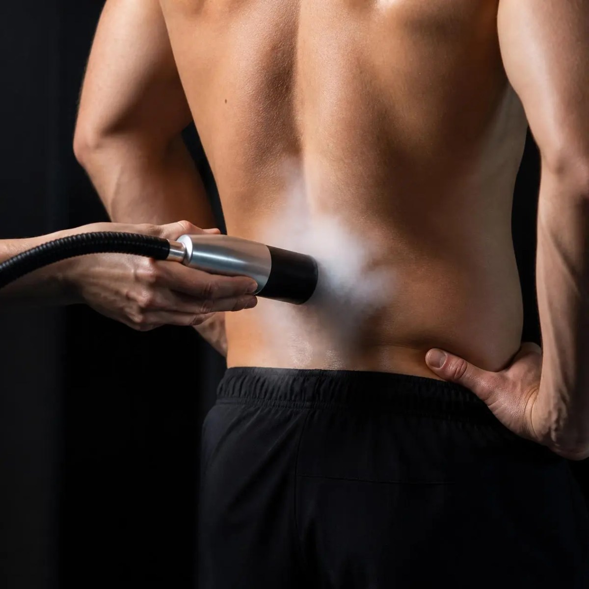 A technician administers a cold therapy recovery session on a man's lower back in Schaumburg, IL.
