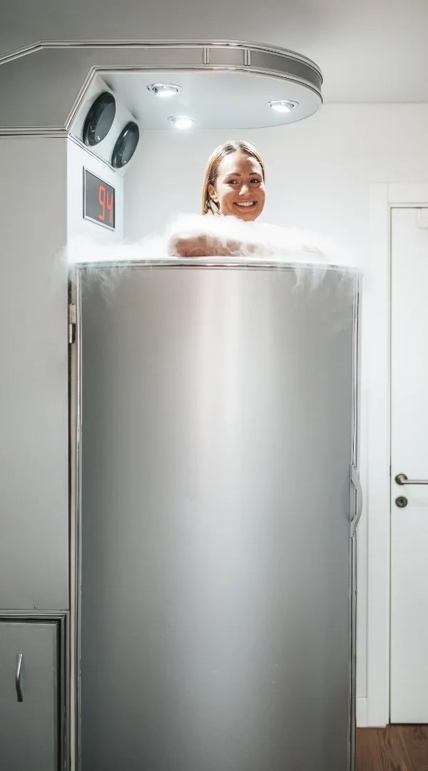 Woman smiling inside a cold vapor whole body cryotherapy chamber in Schaumburg.