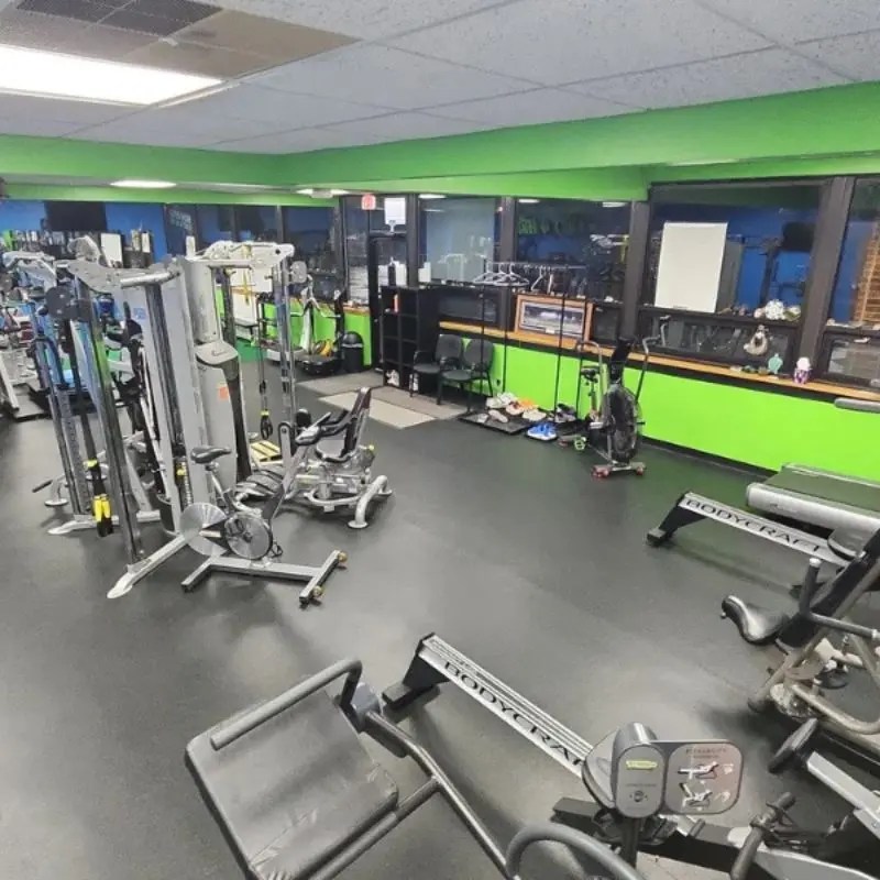 A modern cardio area featuring rowers and stationary bikes inside a spacious custom workout facility in Barrington, IL.