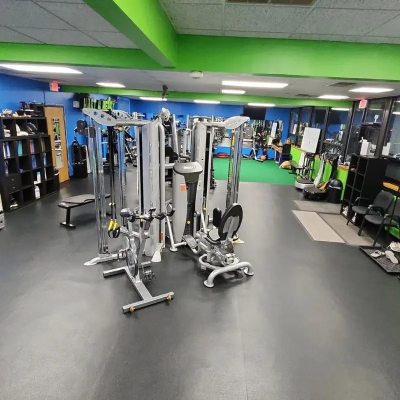 A versatile dual cable crossover pulley machine standing on black flooring inside a personal fitness studio in Inverness, IL.