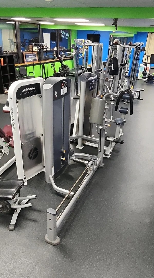Row of weight stack exercise machines lining rubber gym flooring in Barrington.