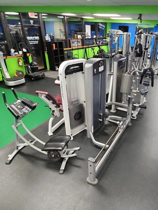 Row of strength training equipment and leg curl machines inside a personal studio in Palatine.
